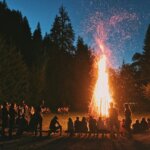 time-lapse photography of a burning bonfire surrounded by people in a camp